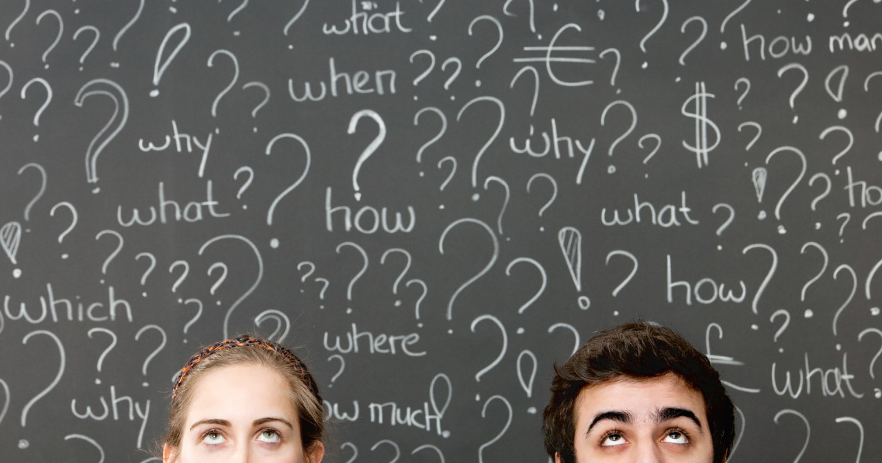 Two faces in front of a chalkboard