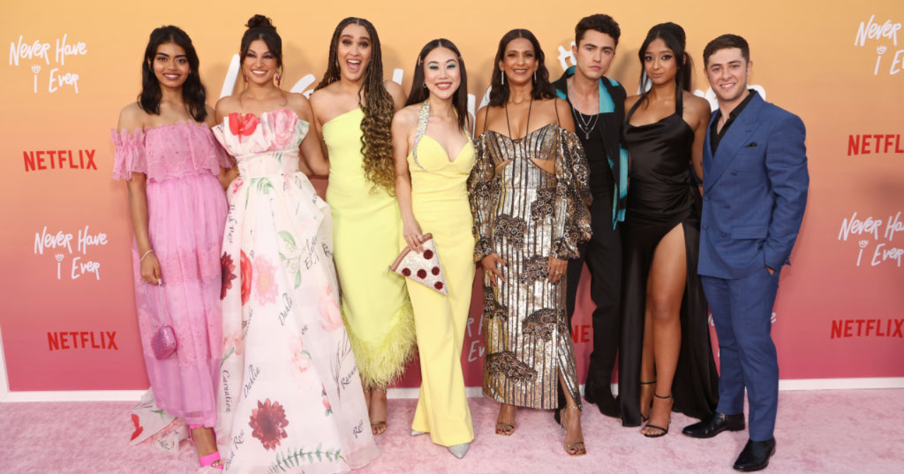 The cast of the TV show Never Have I Ever pose for a photo on a red carpet. 