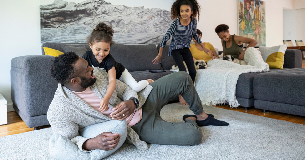 A large family enjoys spending time together on the sofa in their living room. 