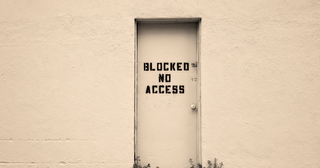 An image of a door with the words, "Blocked No Access" spray painted on it. 