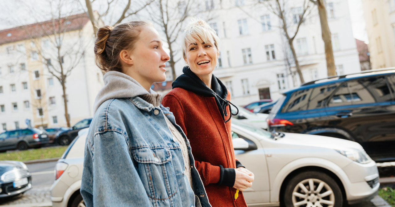 A mother and her teen daughter go for a walk. 
