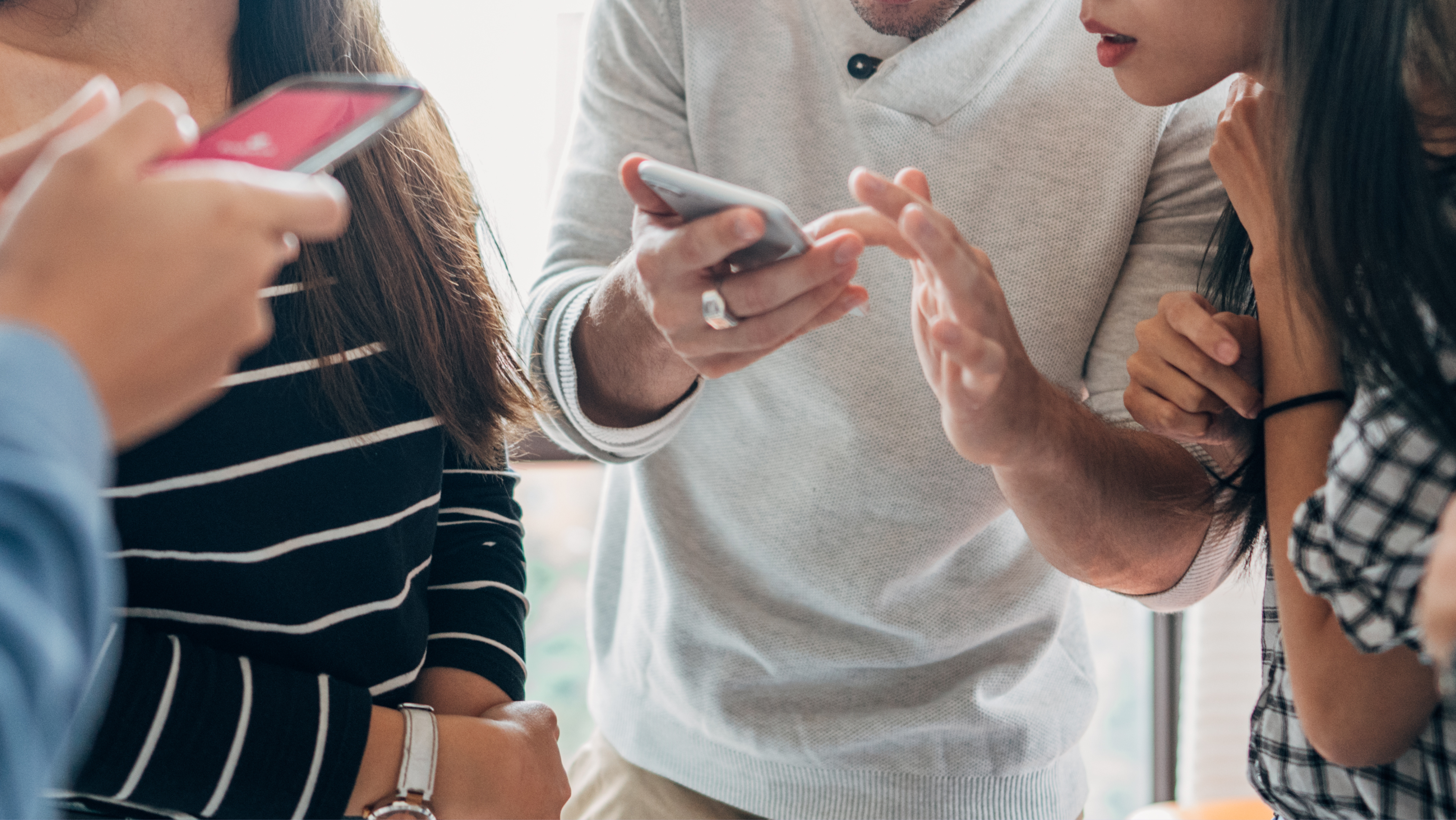 young people looking at cell phones