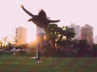 A woman jumps for joy and clicks her heels
