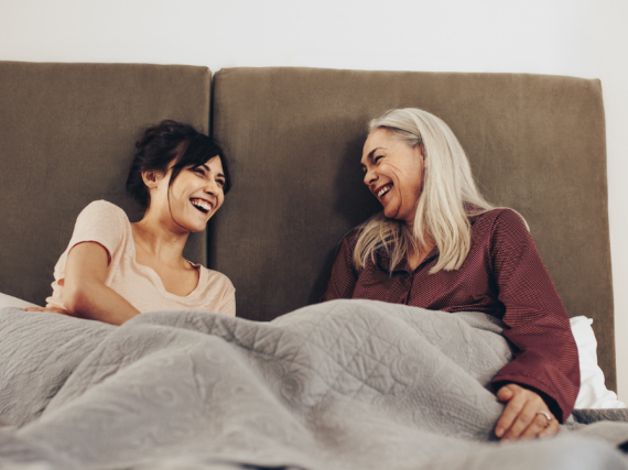A mother and daughter in bed, talking