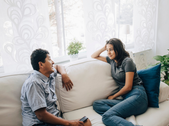 Father and daughter talk on the sofa