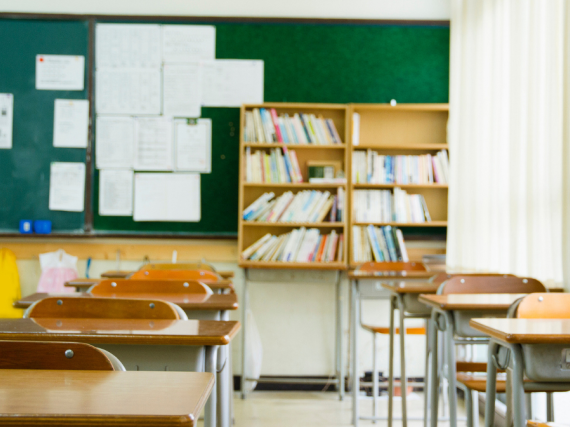 An image of desks in an empty classroom. 