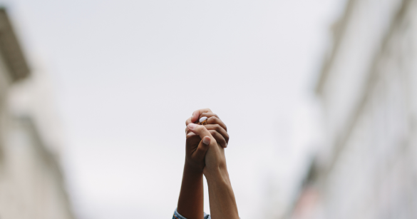 Two people hold hands and raise them up in the air 